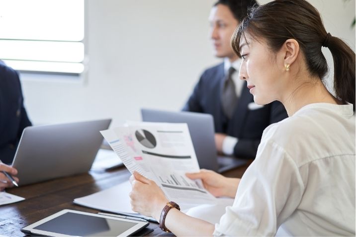 マーケティング会議中に資料を見ている女性