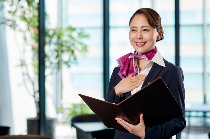 女性のサービススタッフが笑顔で対応している様子